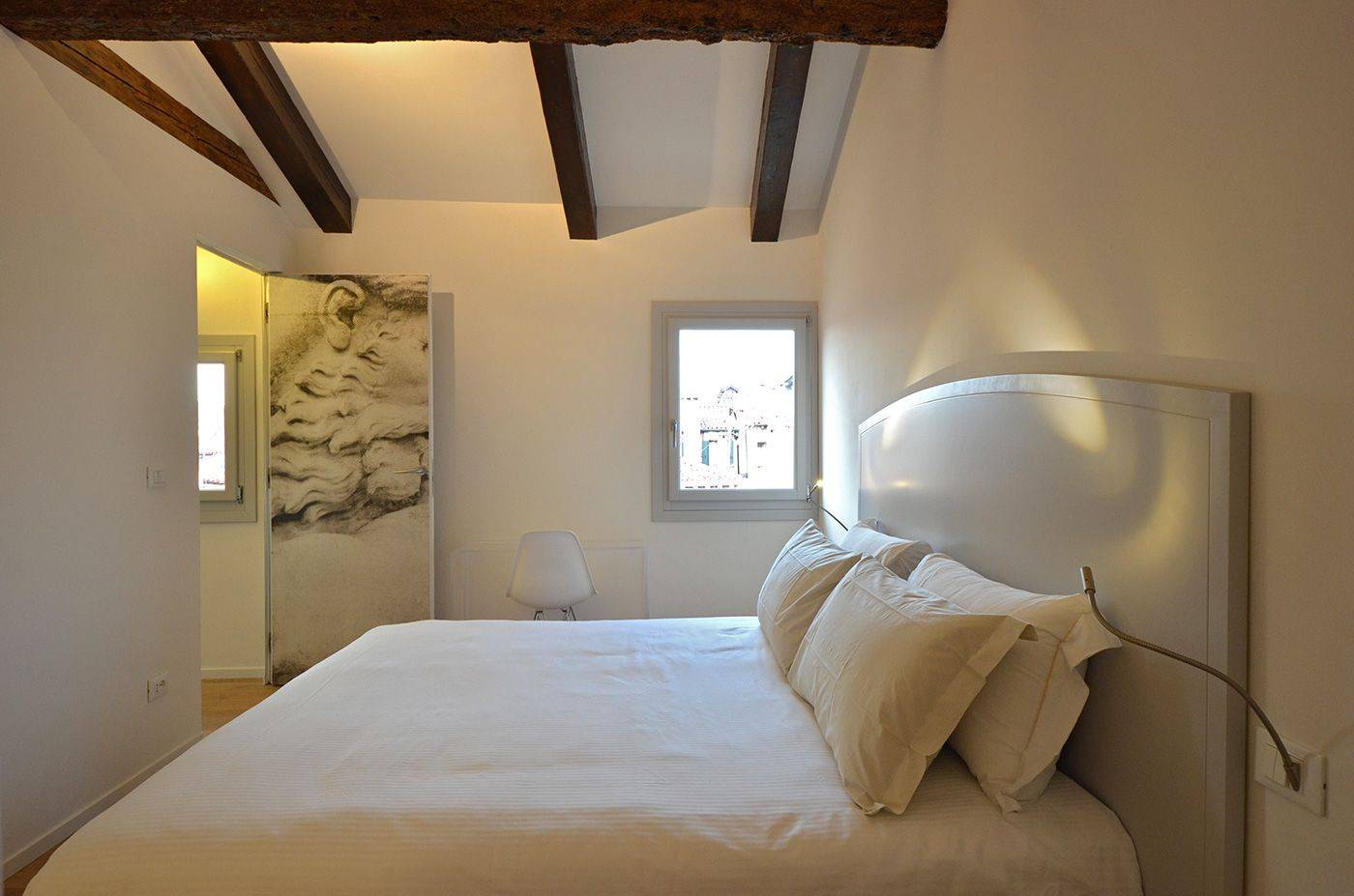 the bedroom features view on the roof-tops and wooden beams