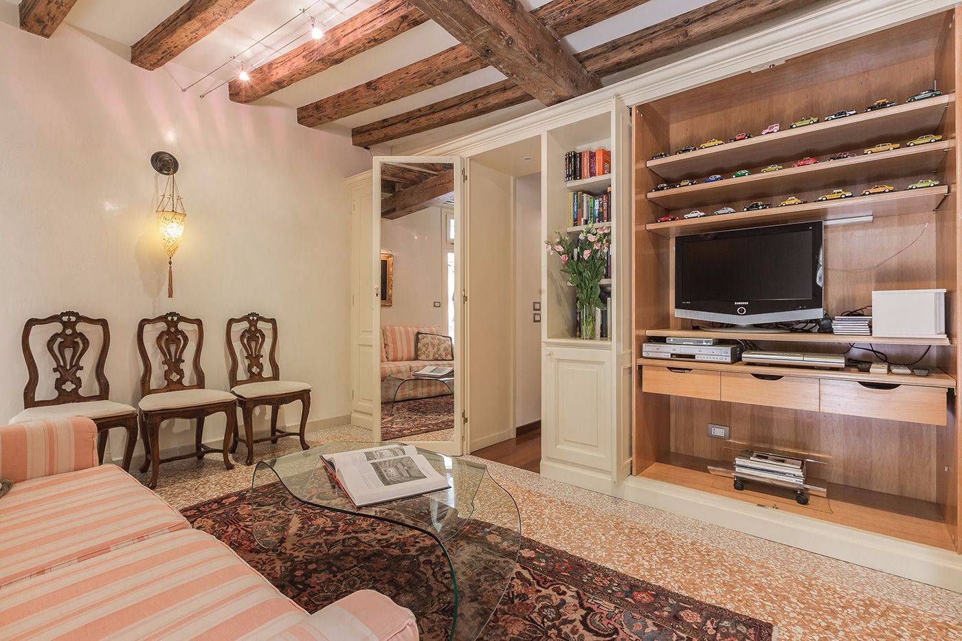 the living room is equipped with a large TV, DVD player, sound system and a library 