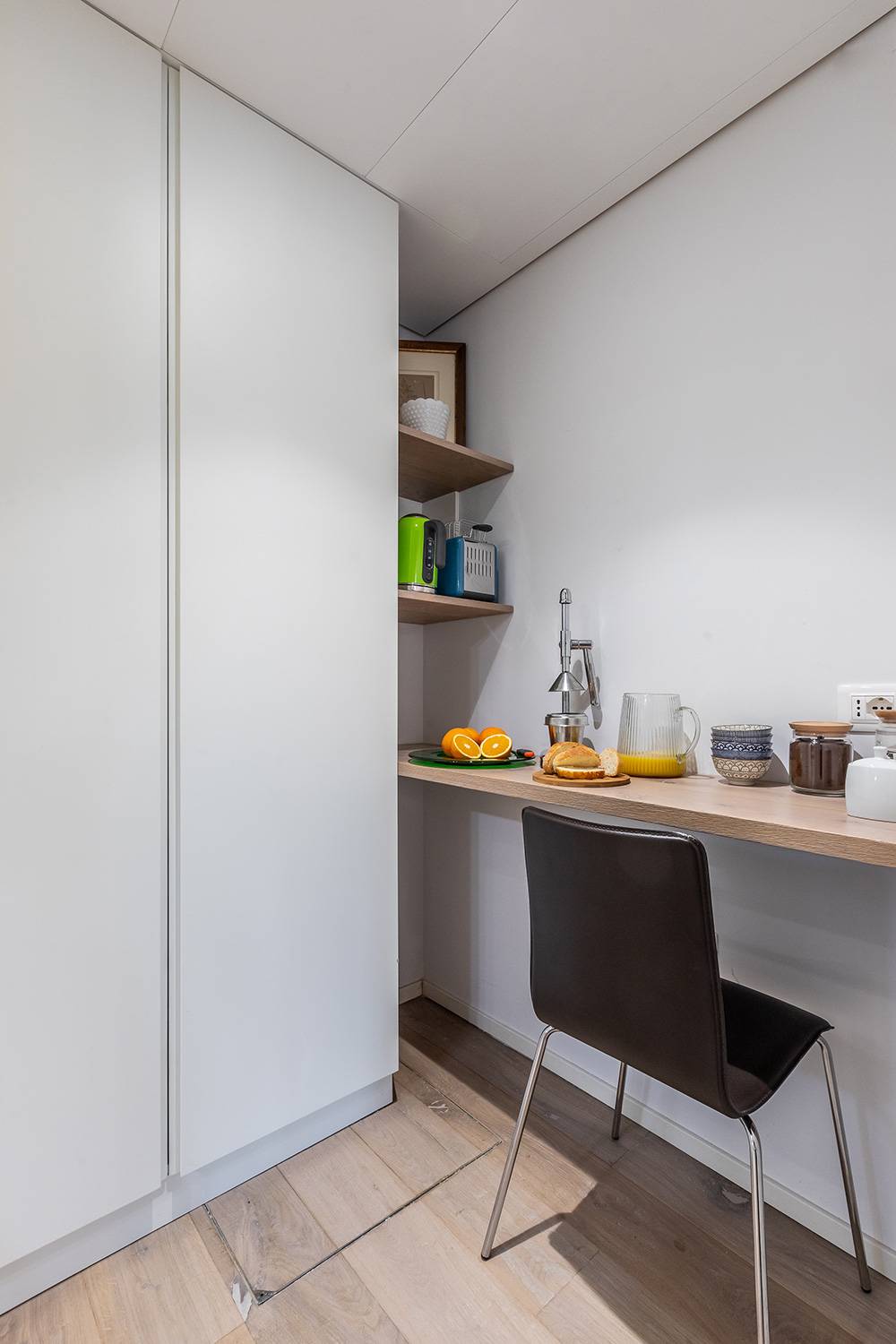 there is a breakfast corner with kettle and toaster next to the closet