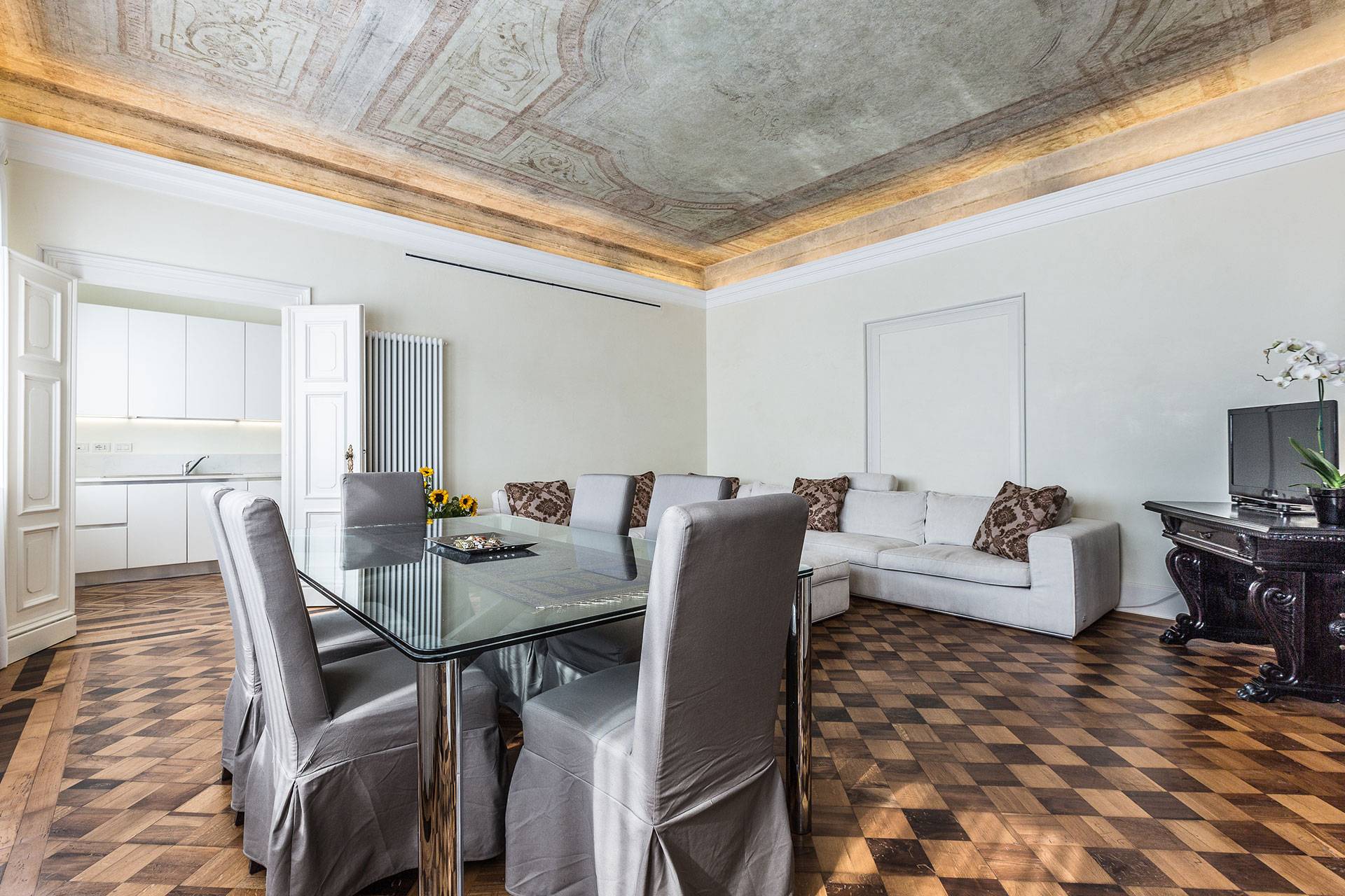 antique partuet flooring and original frescoed ceiling confer a unique charm to the ambience