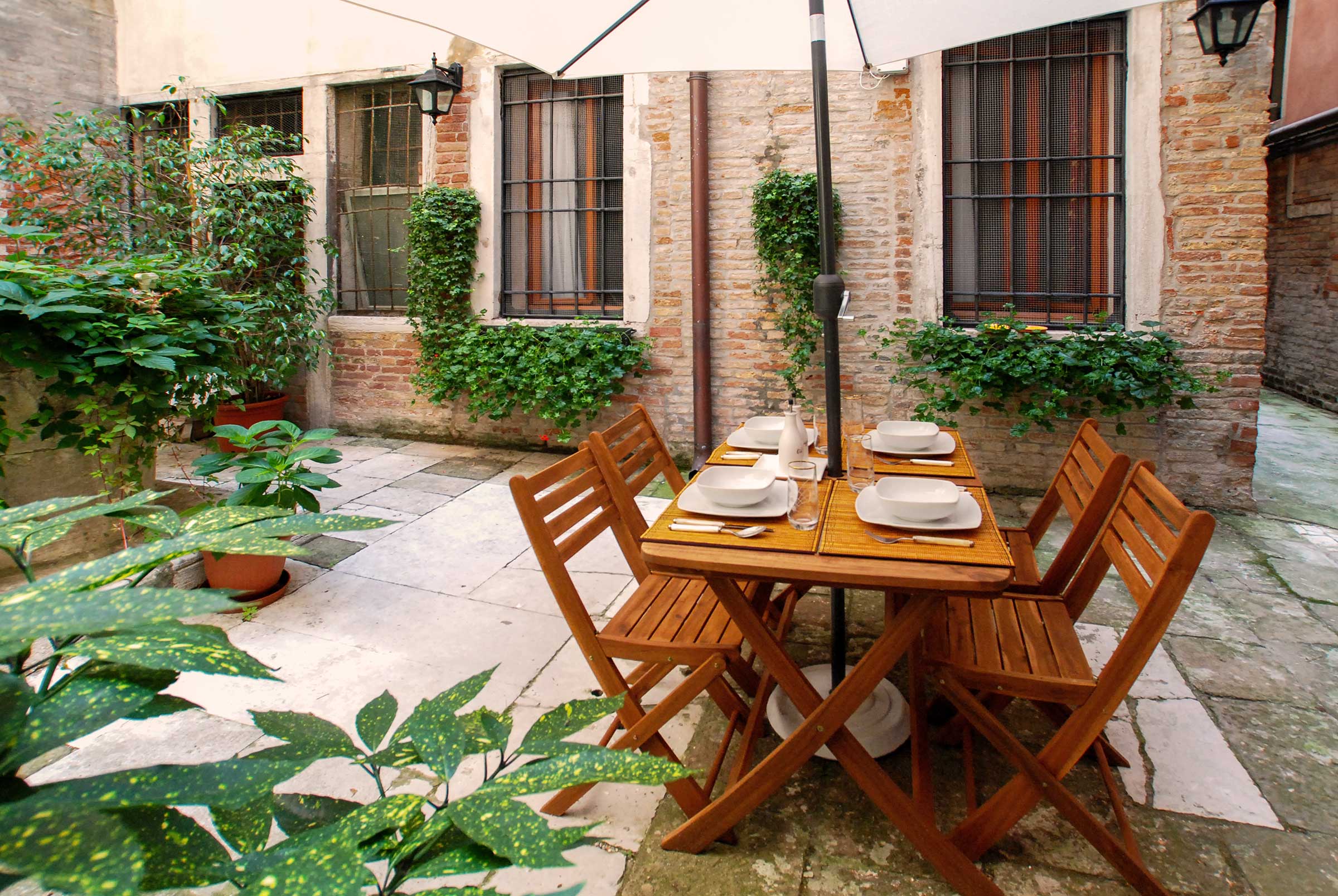 there is a private backyard with outdoor table and chairs