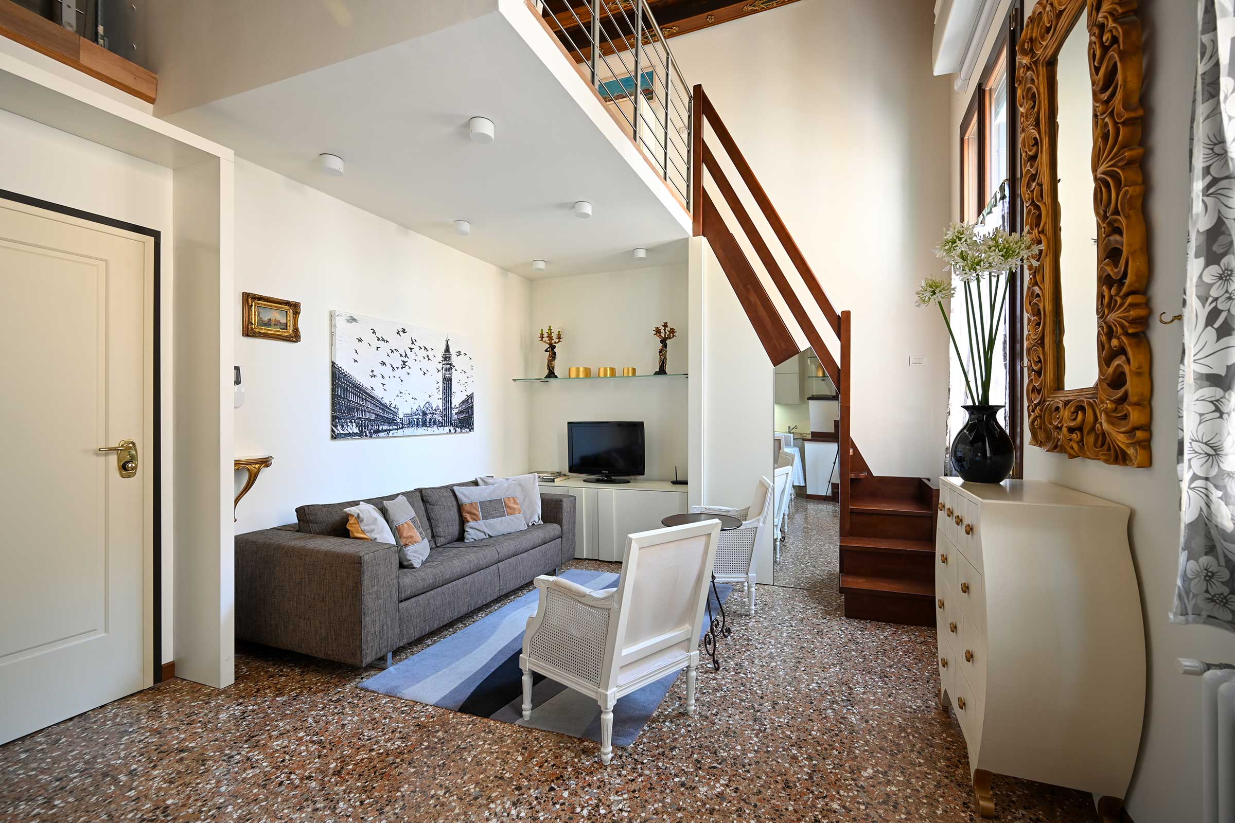 Tommaseo apartment living room with stair case to access the mezzanine level