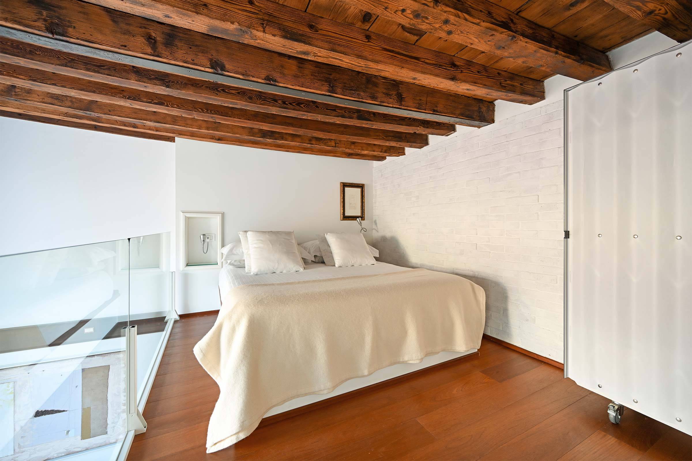 spacious bedroom in the gallery, the height of the wooden beams is about 180 cm