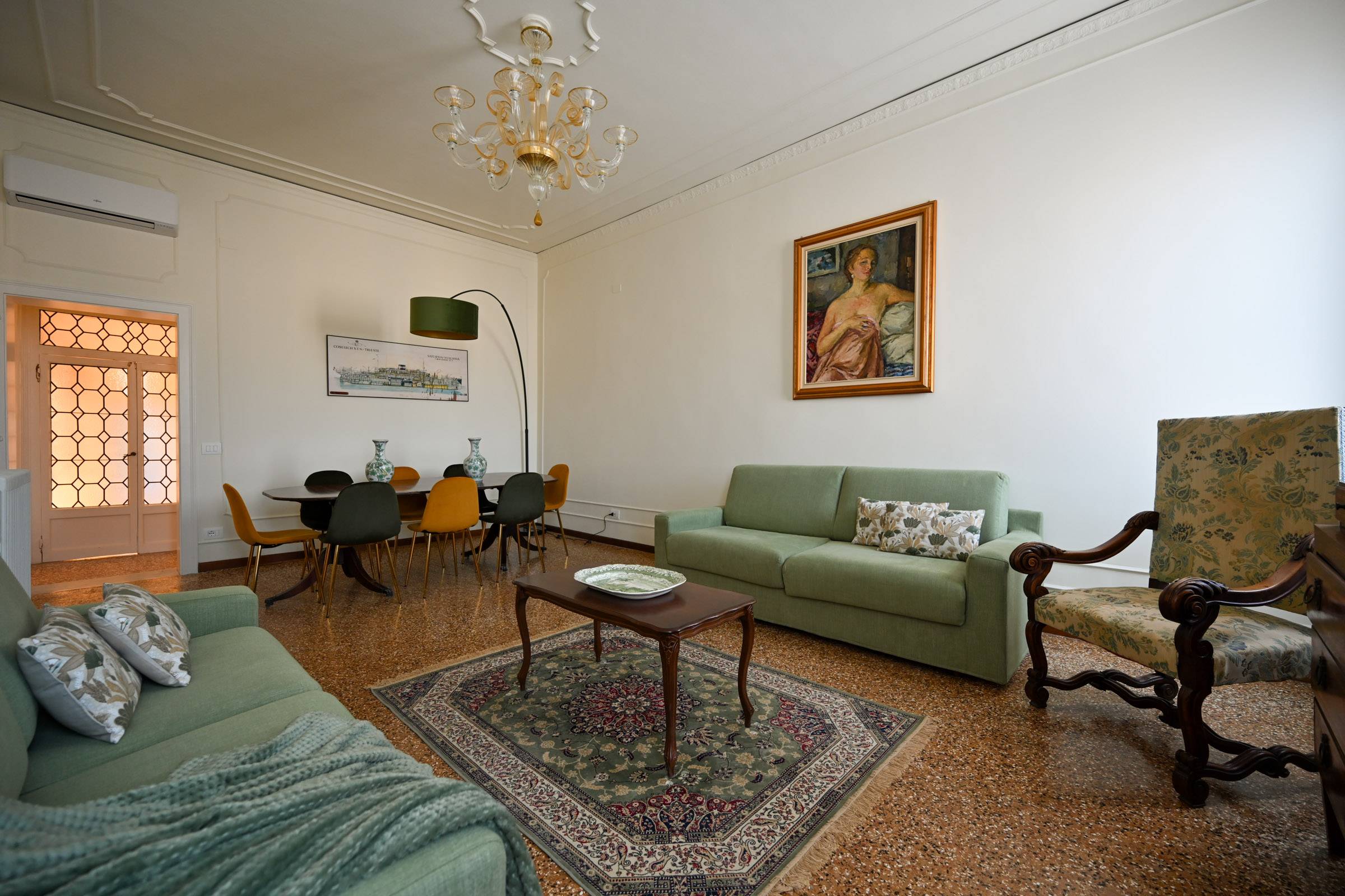 there is a double sofa-bed and a large wooden table with plenty of comfortable sitting space